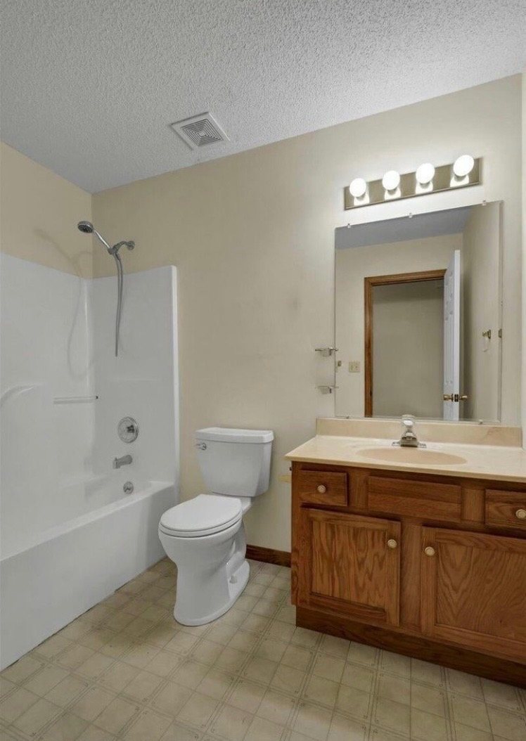 Dated bathroom before remodel with vinyl floor and oak vanity