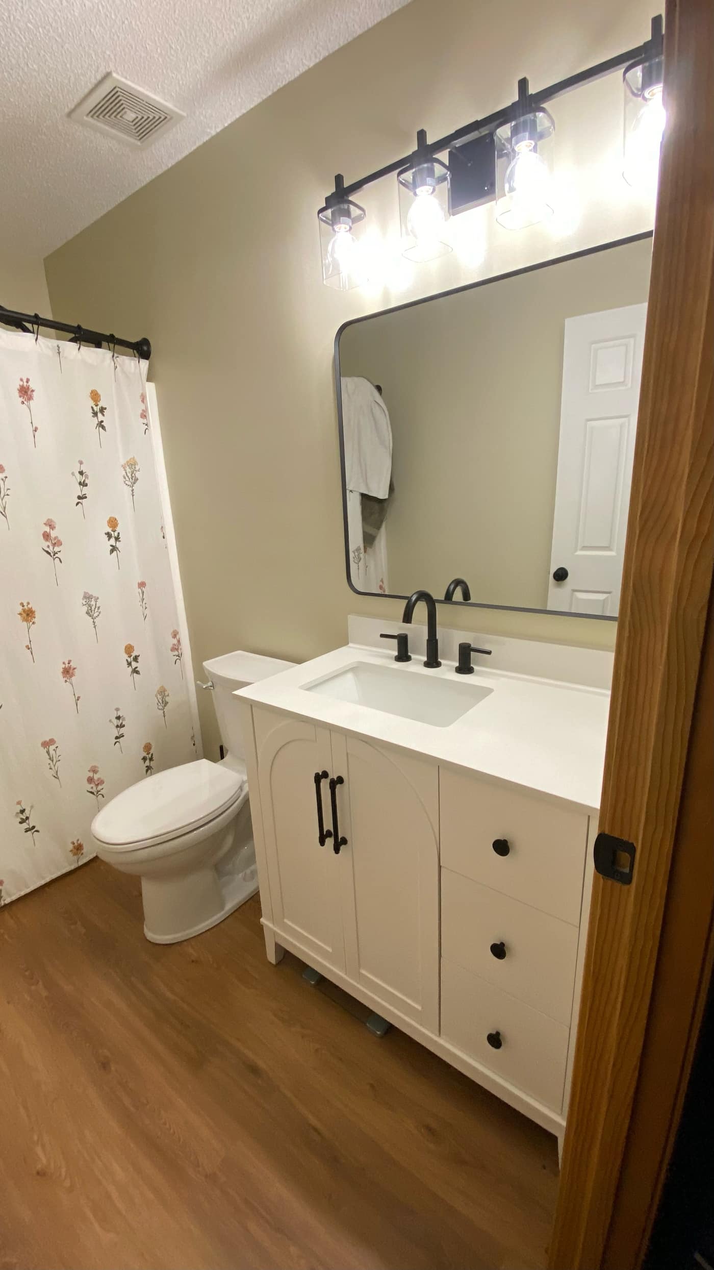 Remodeled bathroom with white vanity and matte black fixtures